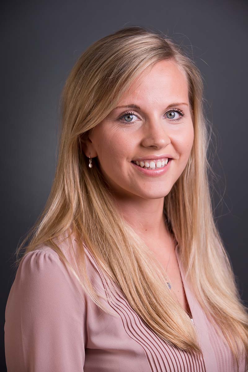 Staff business headshot of a pretty young blonde woman with a peach coloured blouse